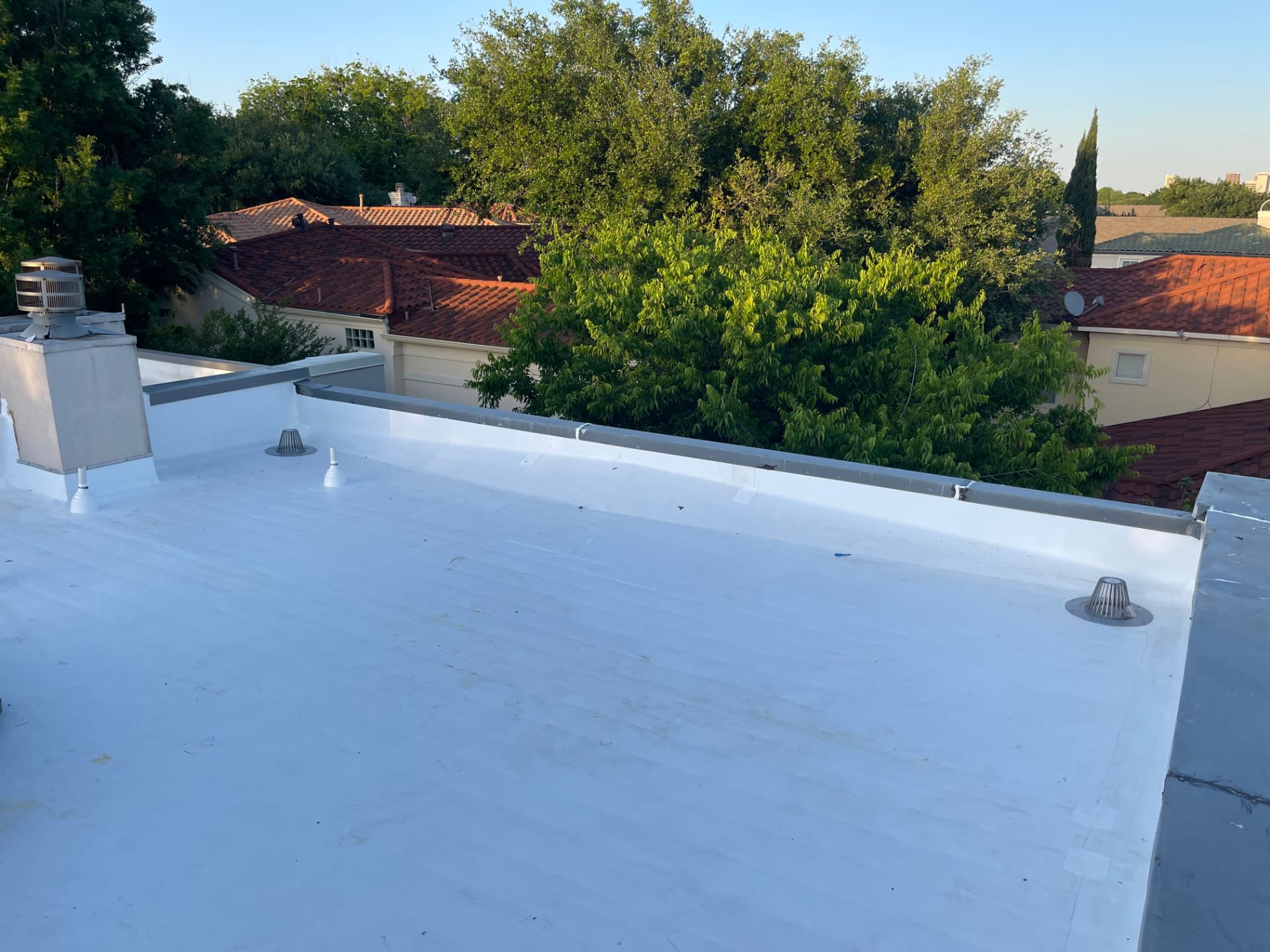 Finished white TPO flat roof with metal coping and roof drains